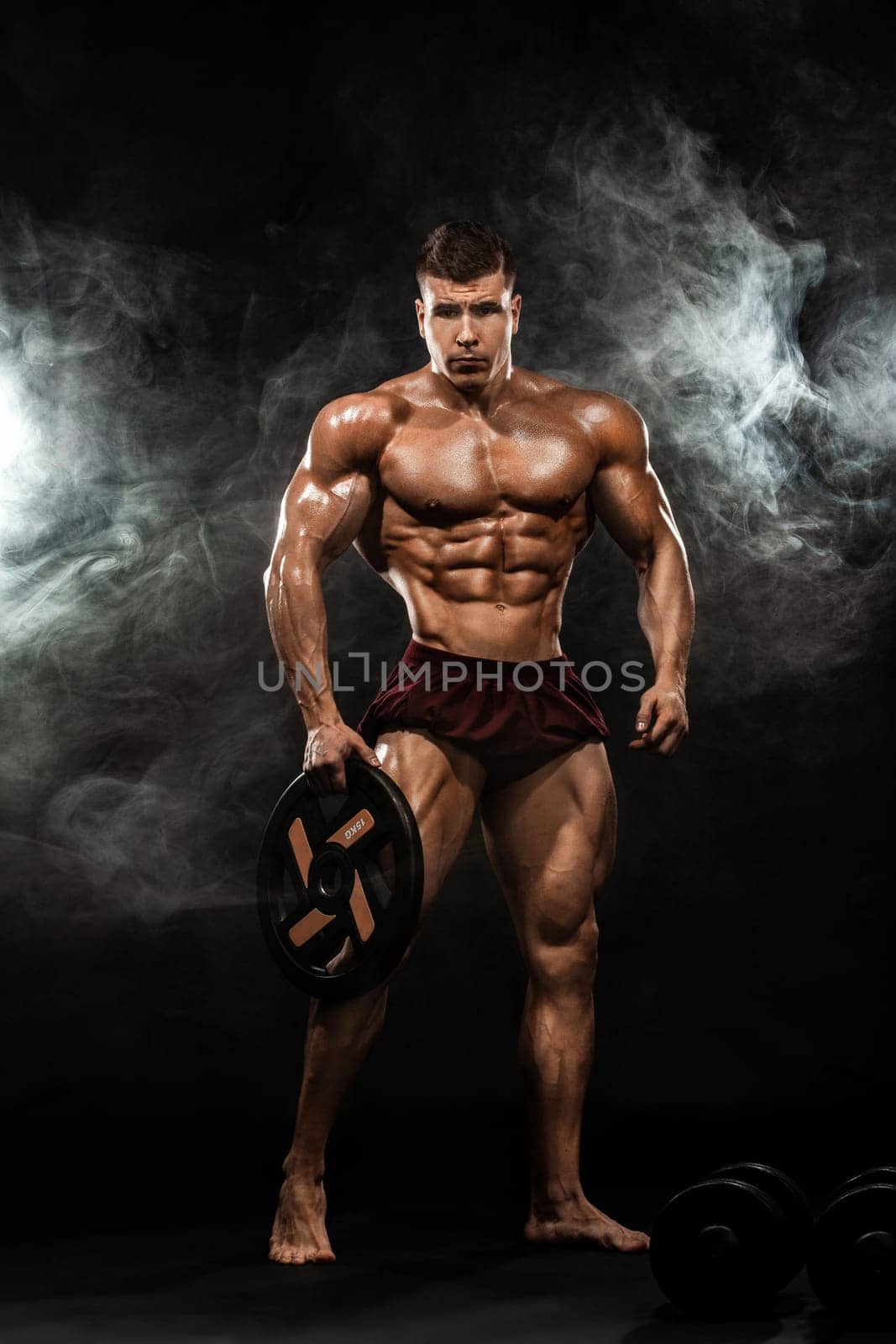 Brutal strong muscular bodybuilder athletic man pumping up muscles with barbell on black background. Workout bodybuilding concept. Copy space for sport nutrition ads. by MikeOrlov