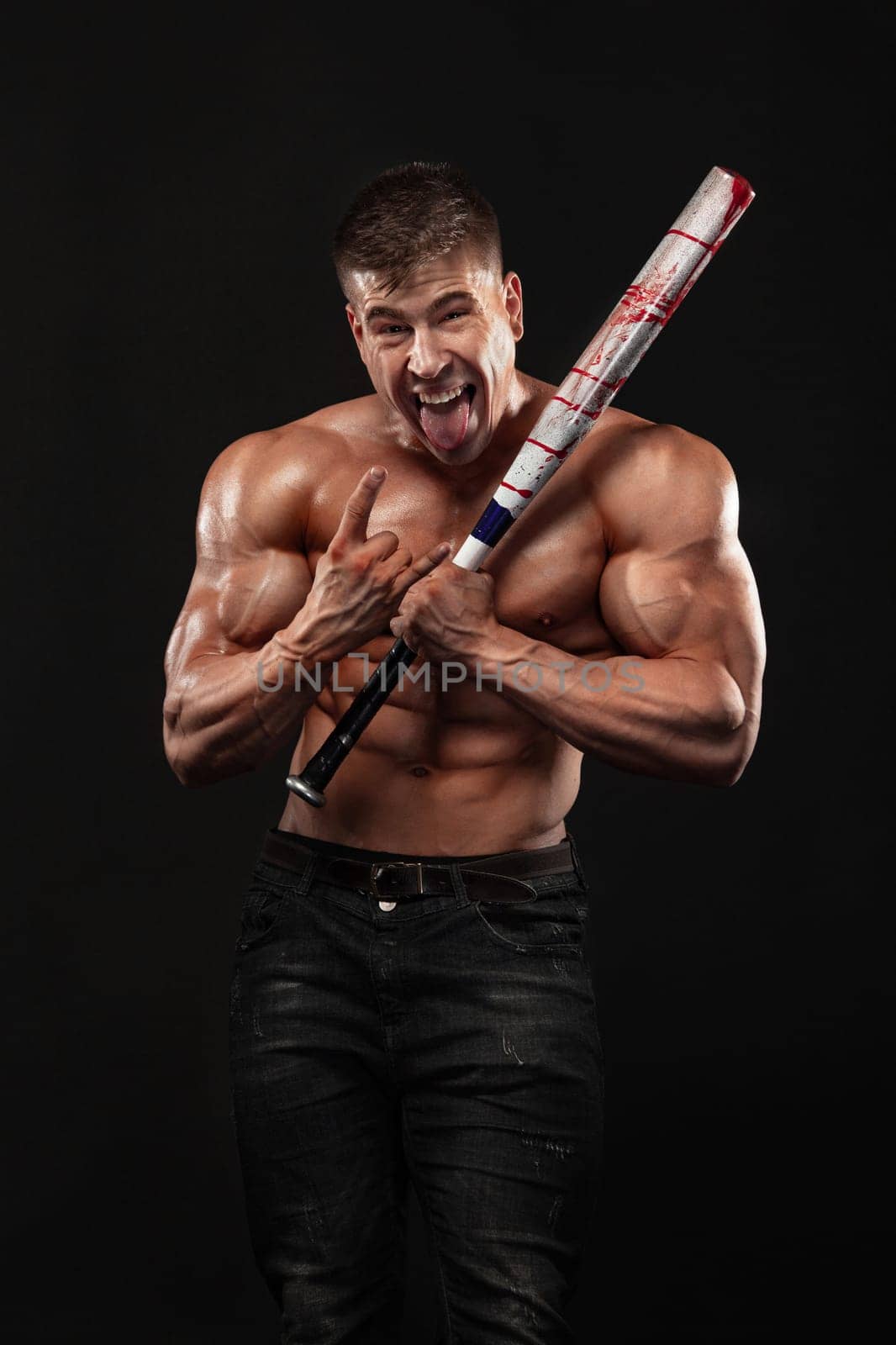 Brutal strong muscular bodybuilder athletic man pumping up muscles with baseball bat on black background. by MikeOrlov