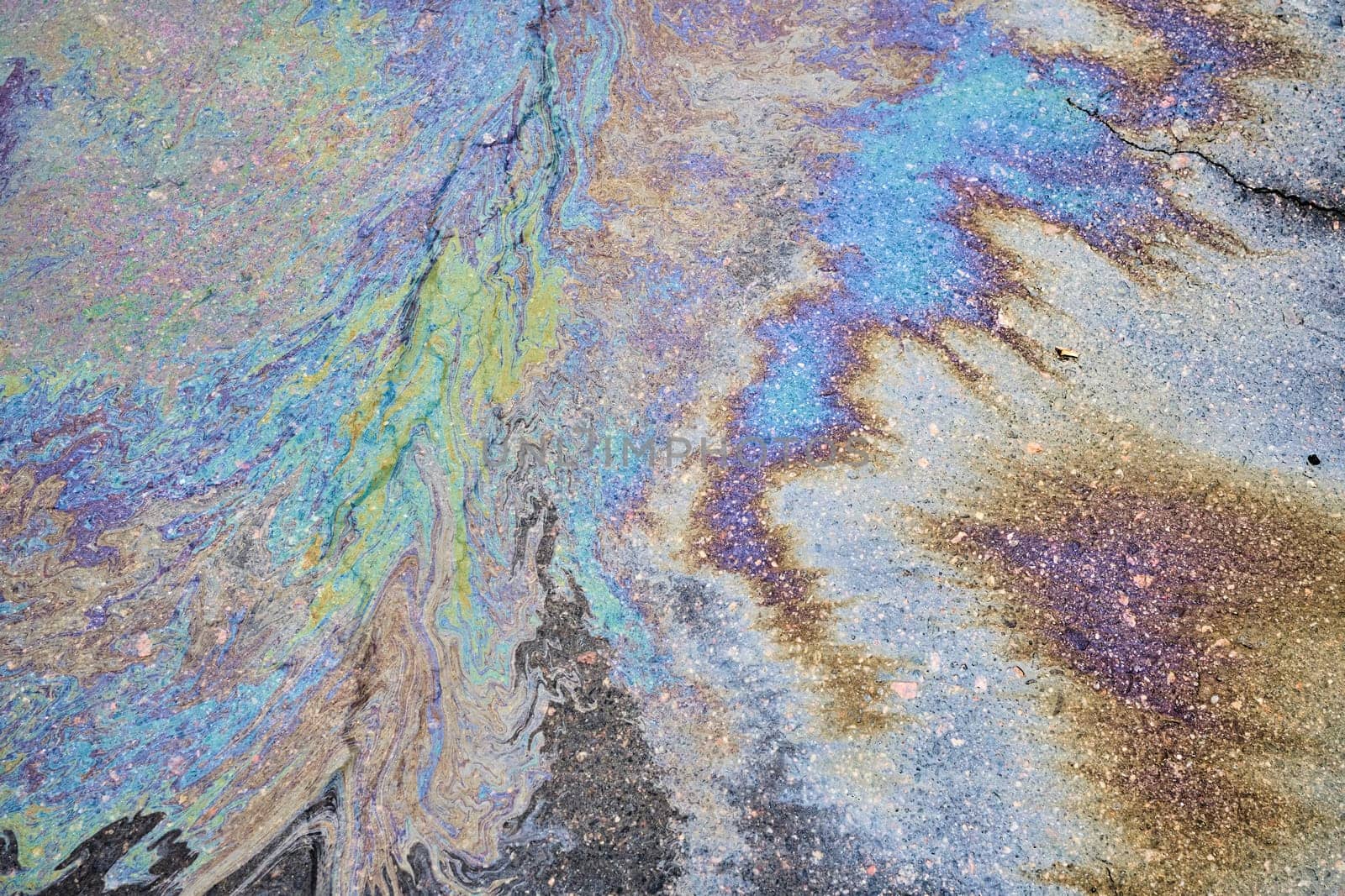 The vibrant texture of a petrol oil spill on a wet pavement