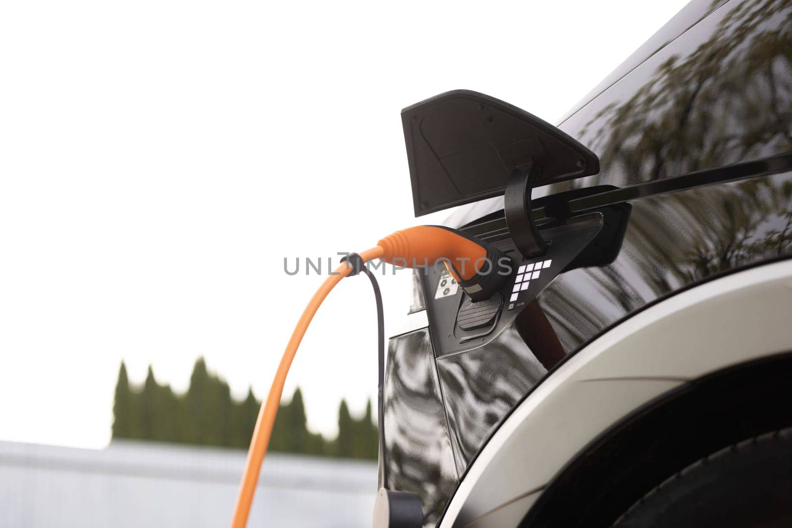 Electric car charging. Electric vehicle charging port plugging in car. Charging technology, Clean energy filling technology.