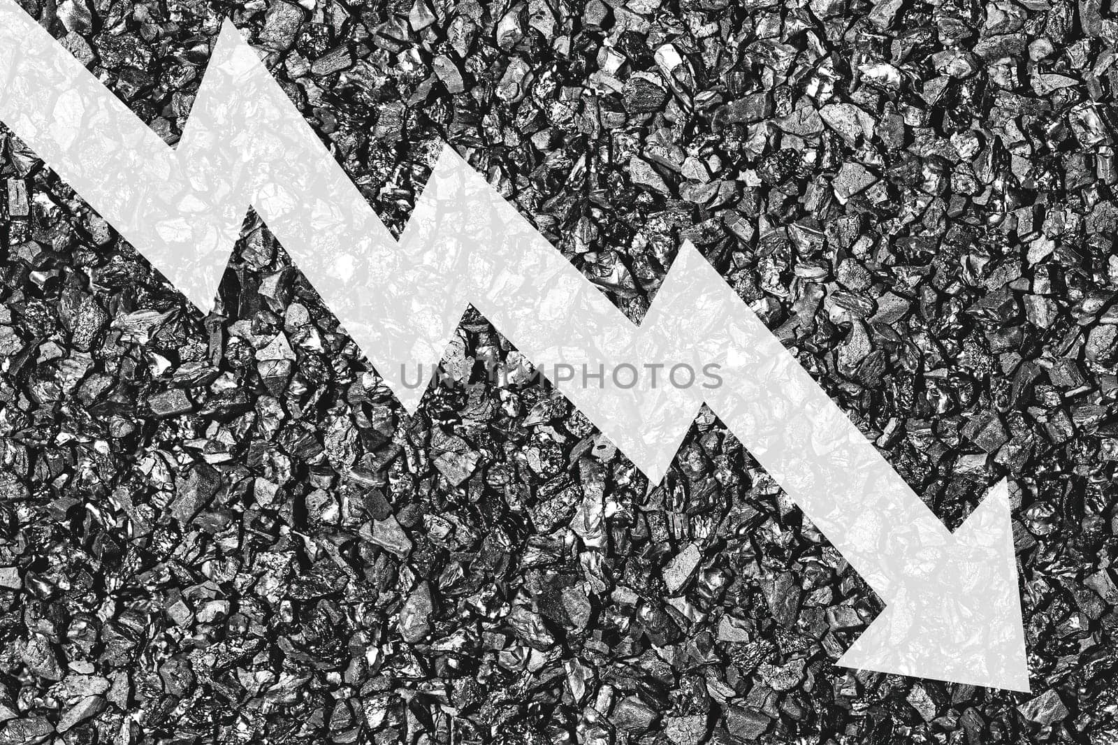 Arrow down on coal background. The concept of falling prices, mining, import, export, production or sales of coal. by Eugene_Yemelyanov