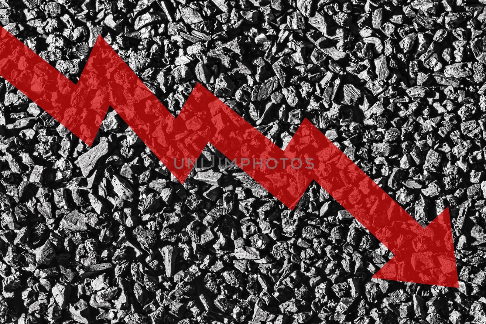 Arrow down on coal background. The concept of falling prices, mining, import, export, production, sales or supply of coal.