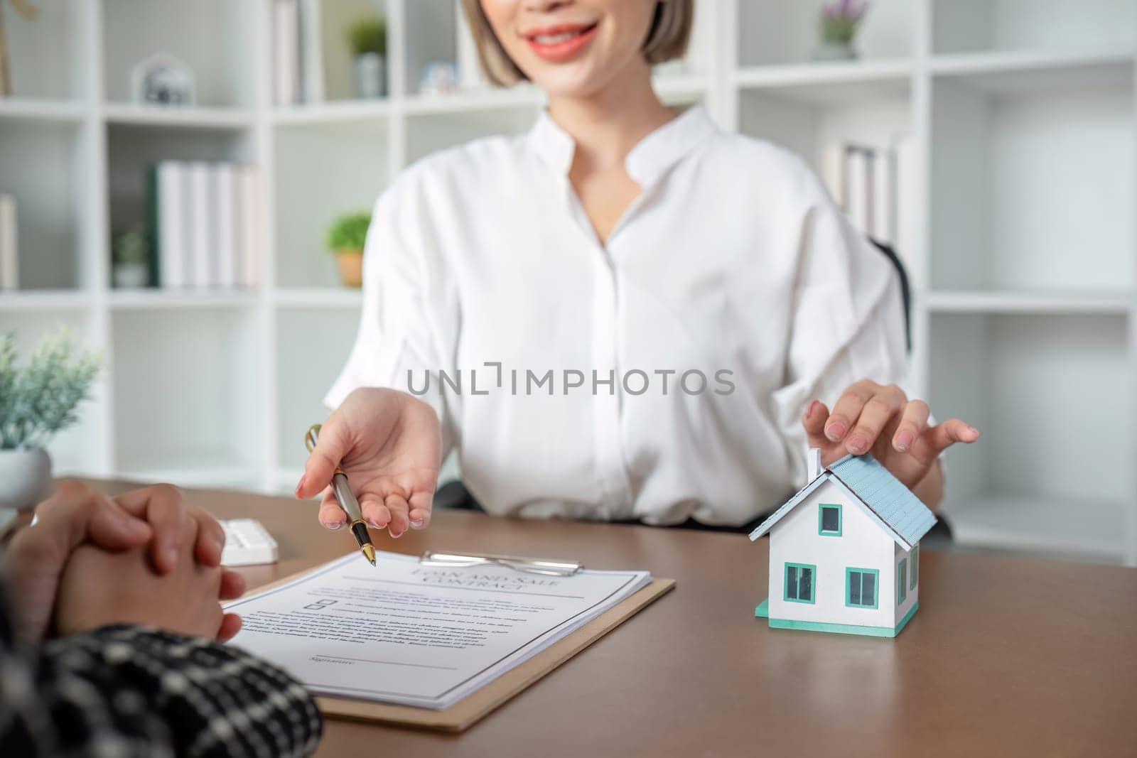 Real estate agent with house plans and keys given to the client after reaching the purchase agreement and signing the contract..