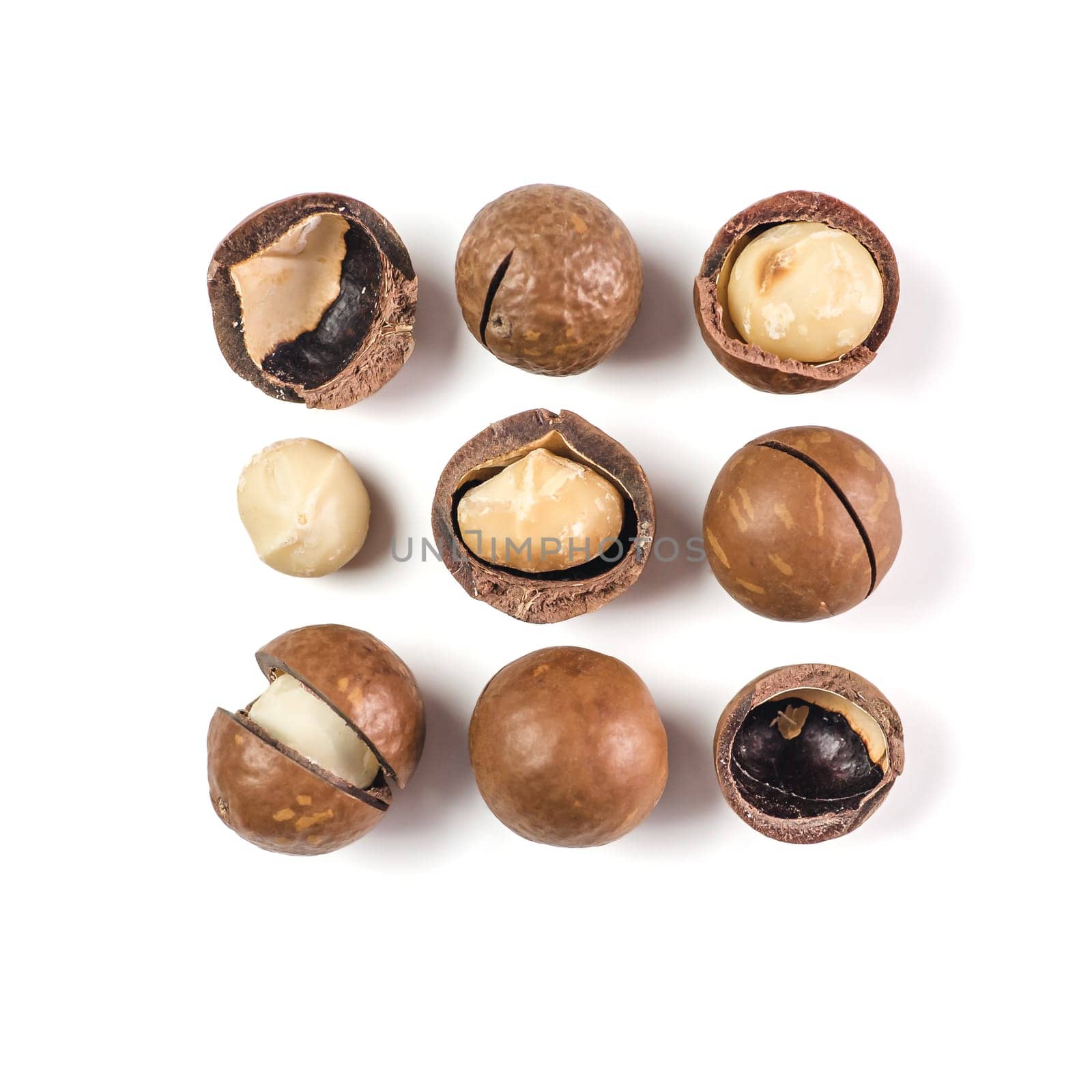 Heap of macadamia nuts on white background with clipping path.. Set of peeled and unpeeled macadamia nuts isolated on white, top view or flat lay. Square. Copy space for text.