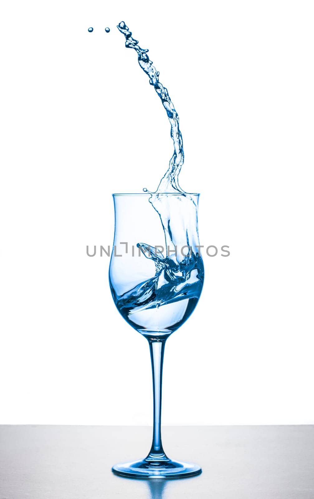 water splashing from wineglass on white background