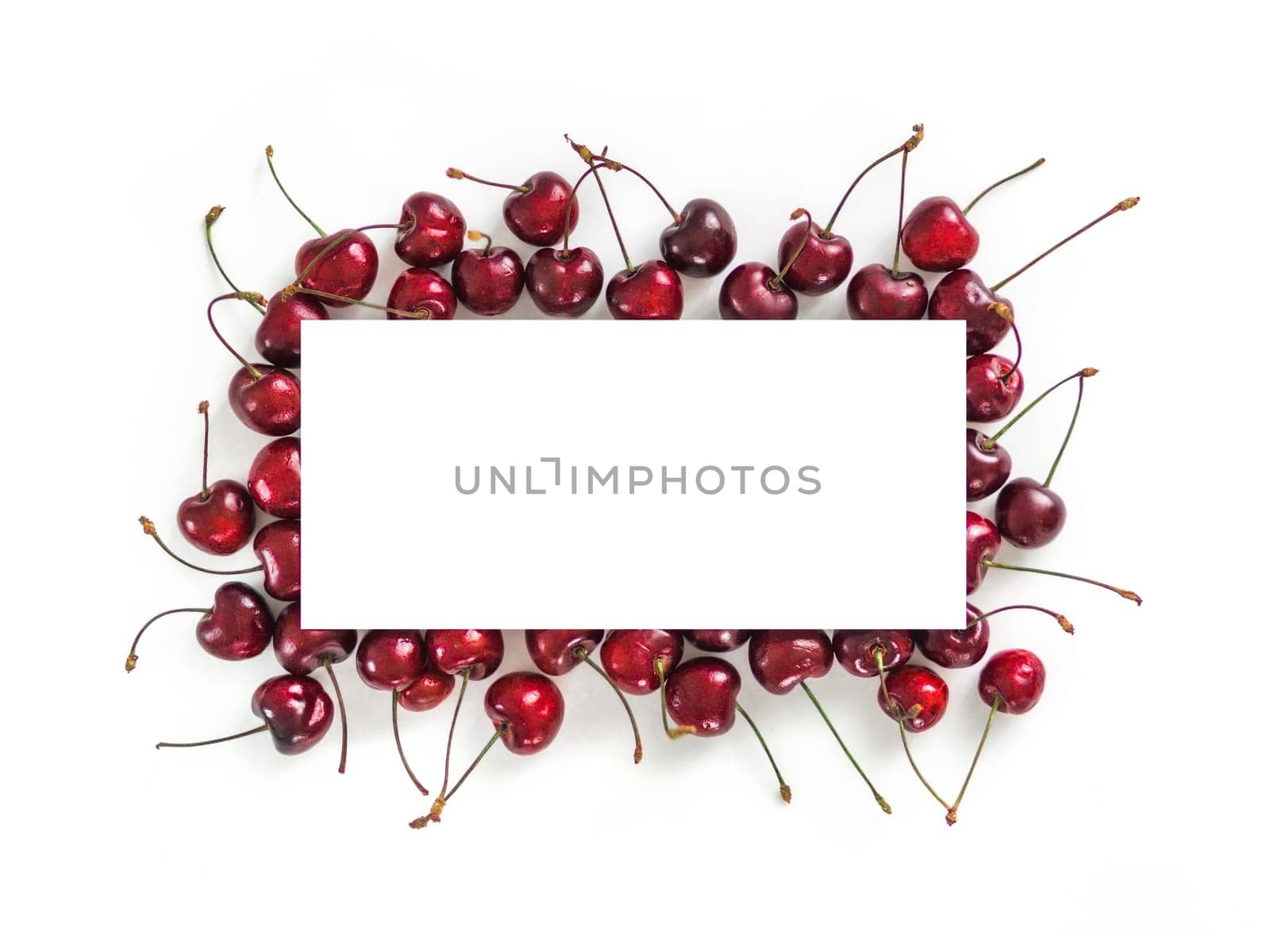 Creative layout with fresh ripe berries. Cherry isolated on white background with white rectangle for copy space. Can use for your design, promo, social media. Top view