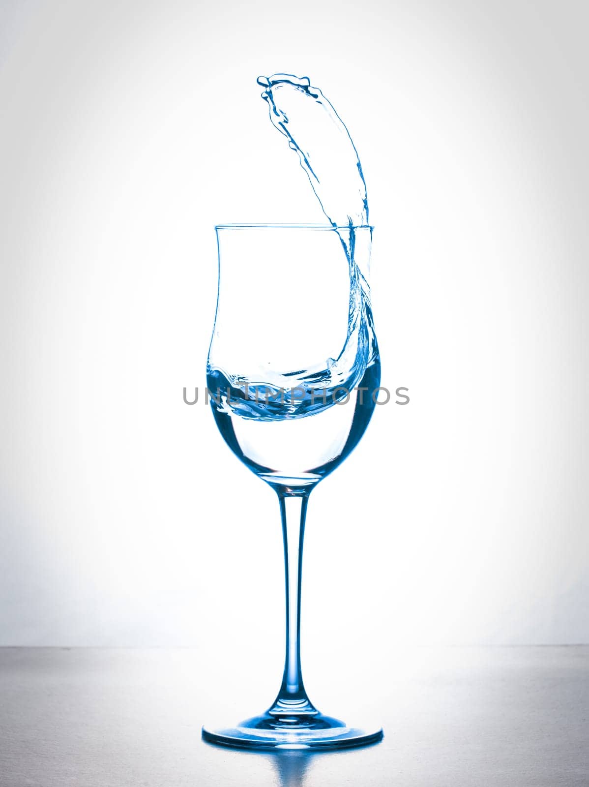 water splashing from wineglass on white background