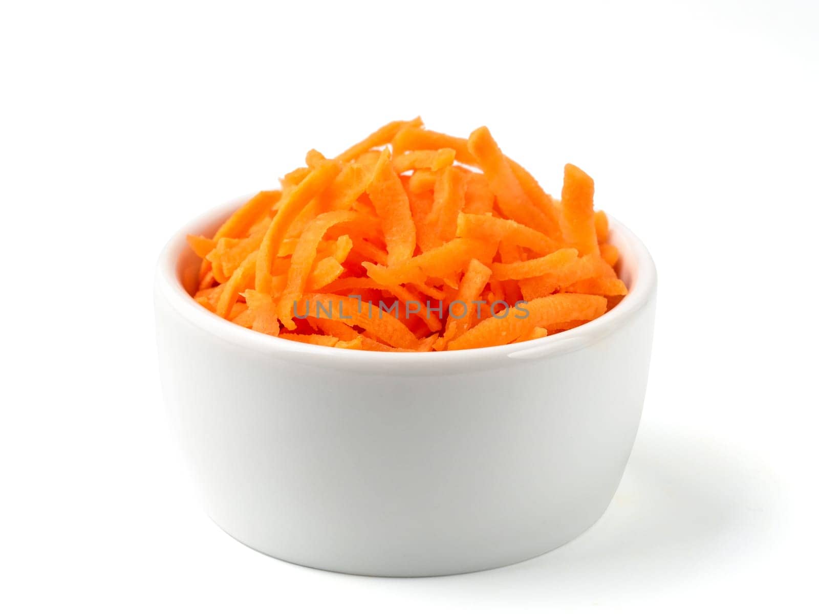Fresh organic shredded carrots in small white bowl. Raw grated carrots isolated on white with clipping path.