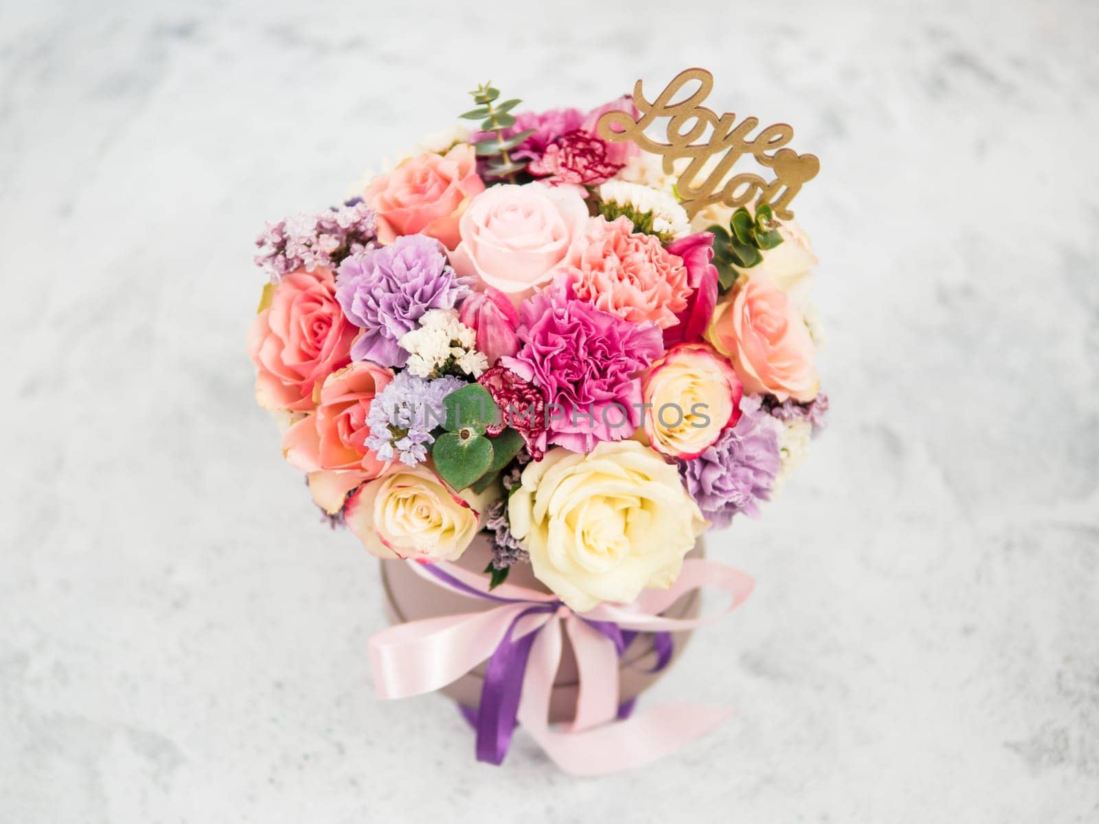 Beautiful bouquet with roses, dianthus, carnation bush, limonium, lilac and tulip. Bouquet with different flowers. Shallow DOF, copy space. Top view.