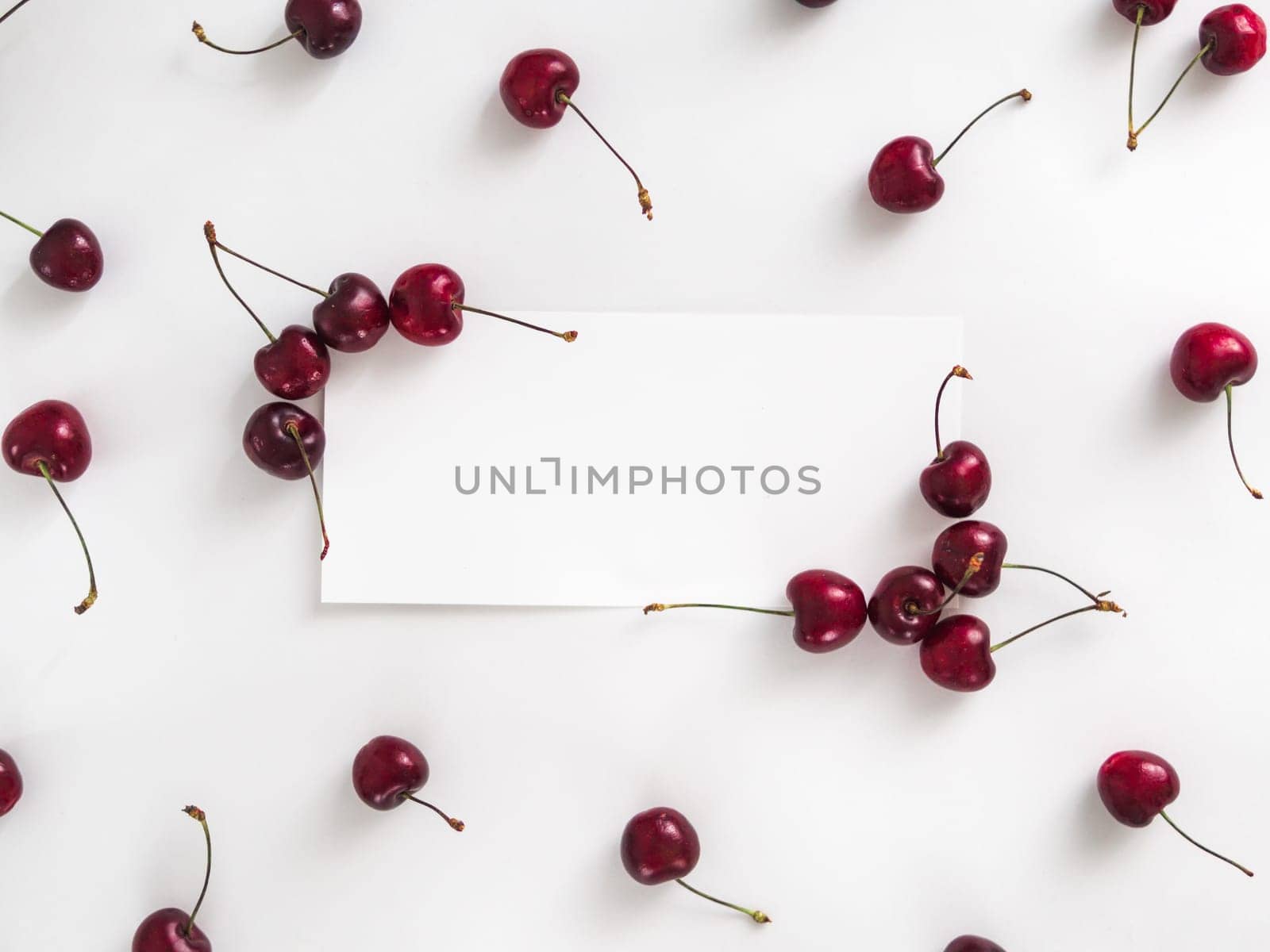 Creative layout with fresh ripe berries. Cherry isolated on white background with white rectangle for copy space. Can use for your design, promo, social media. Top view