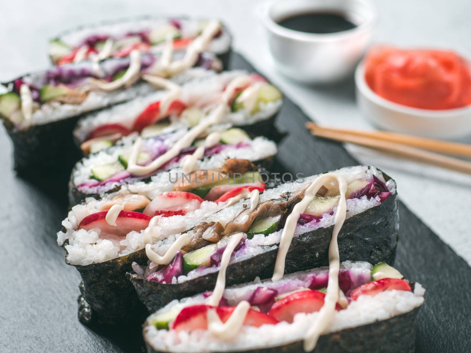 Vegan sushi sandwich onigirazu with vegetables. Healthy dinner recipe and idea. Colorful japan sandwich onigirazu with red cabbage, radish, cucumber, mushrooms. Trend food. Close up, shallow DOF