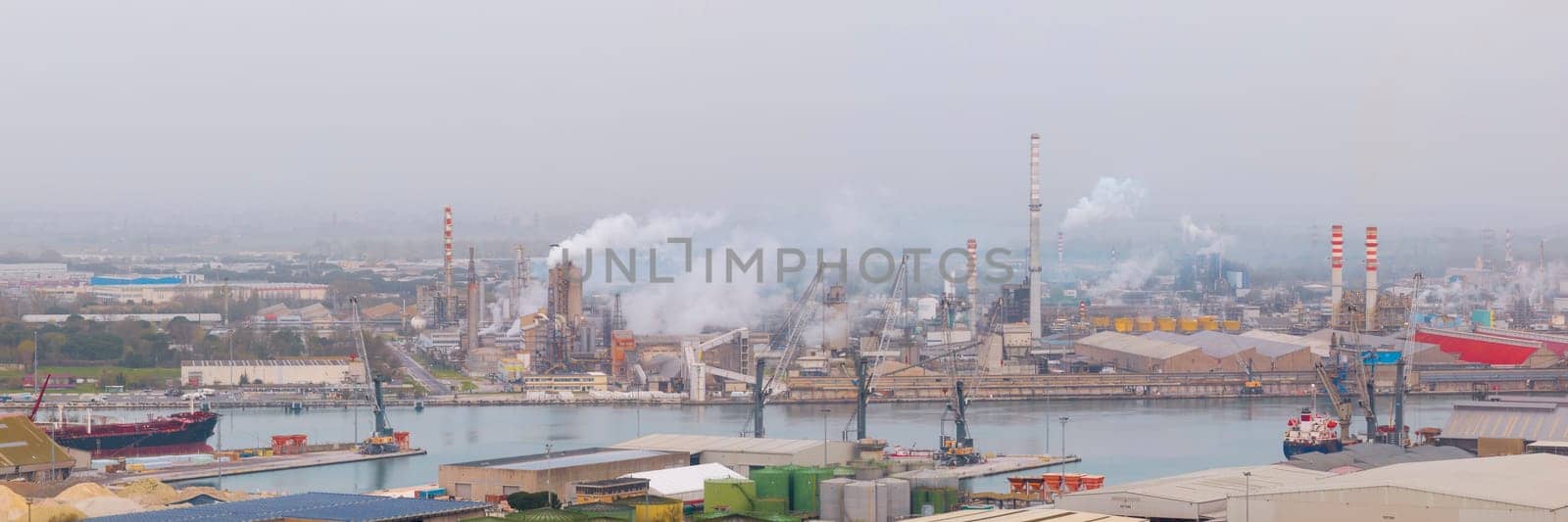 Panorama of hydrocarbon refinery and liquefied natural gas tanks at cloudy day by Robertobinetti70