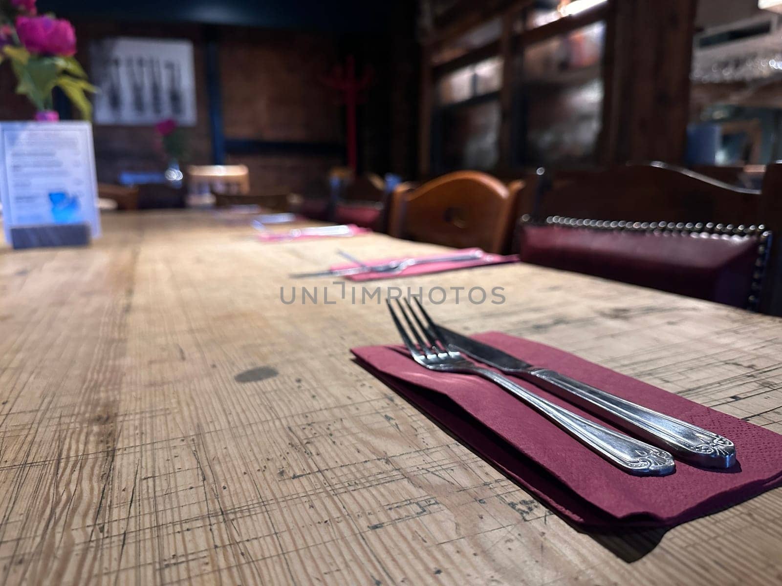 Empty restaurant table with cutlery and napkins
