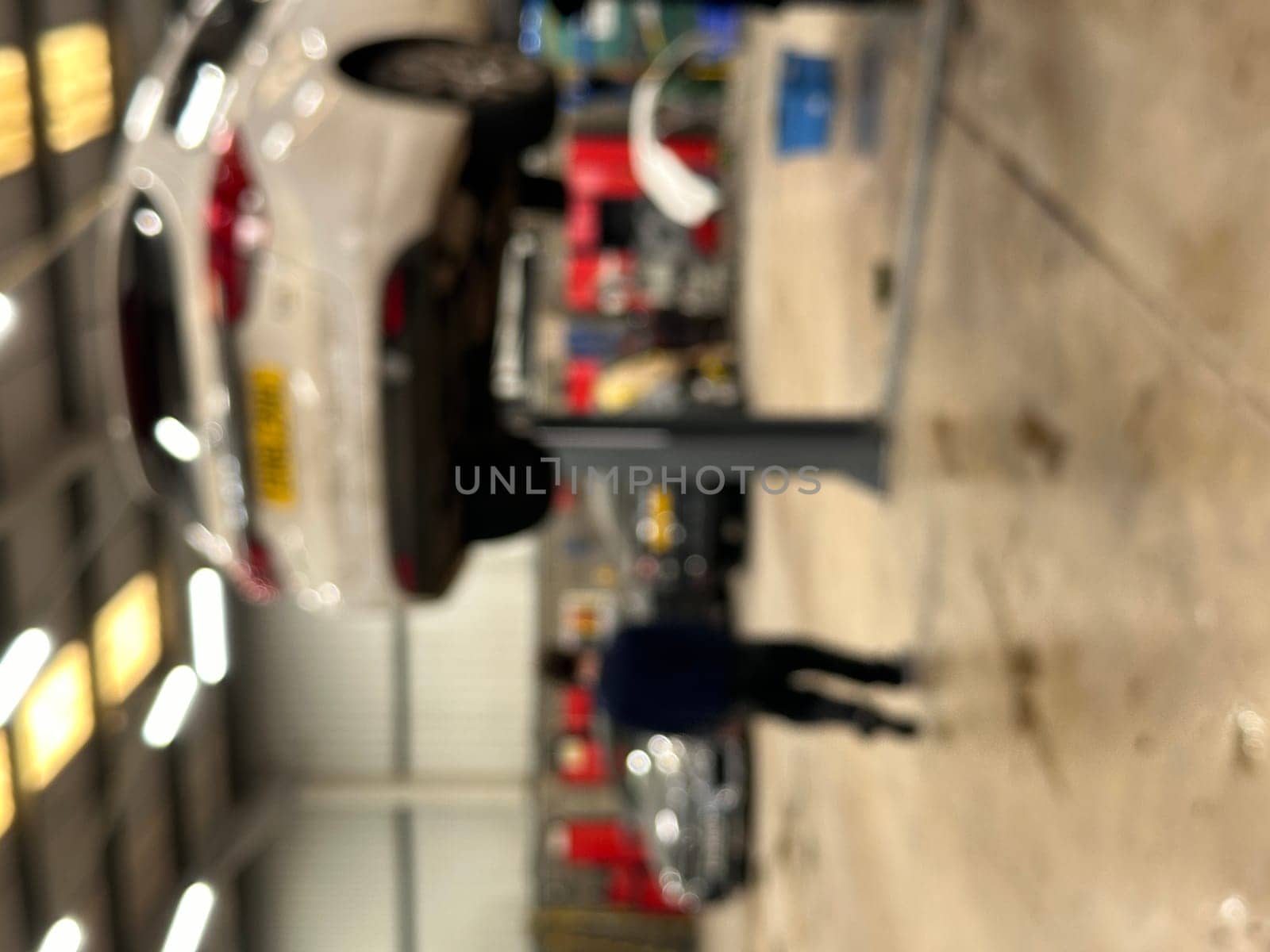 Blurred vertical shot of a car on a lift at cr repair shop