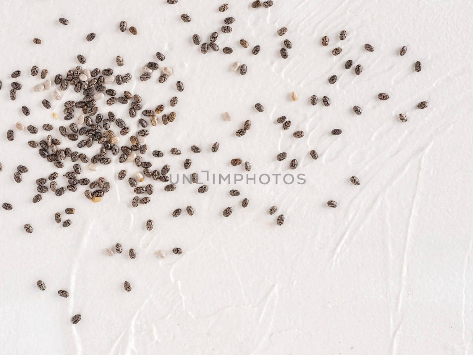 Chia seeds with copy space. Chia seed on white concrete textured background. Top view or flat lay. Copy space. Healthy food and diet concept