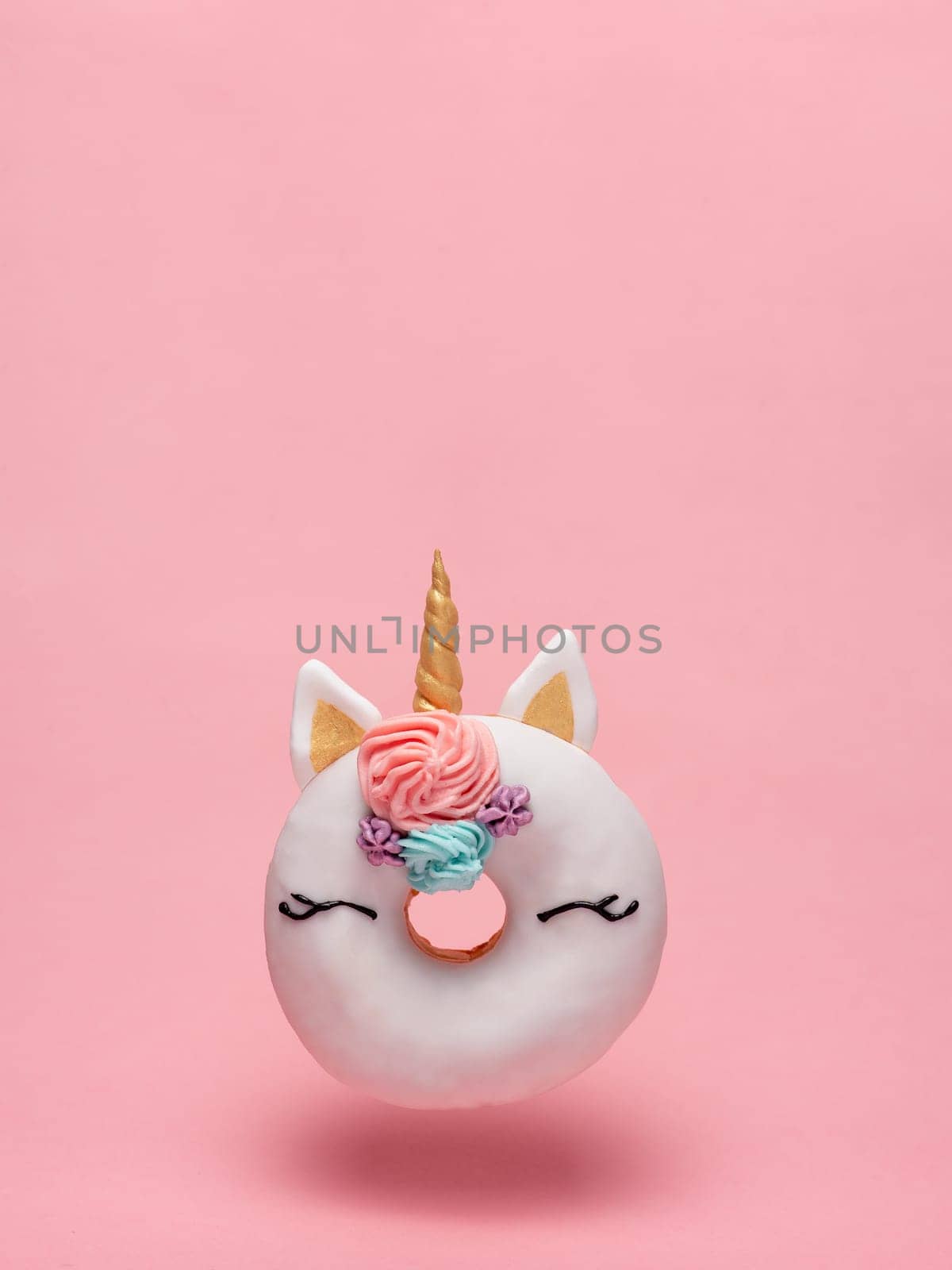 Unicorn donut flying, pink background, copy space by fascinadora