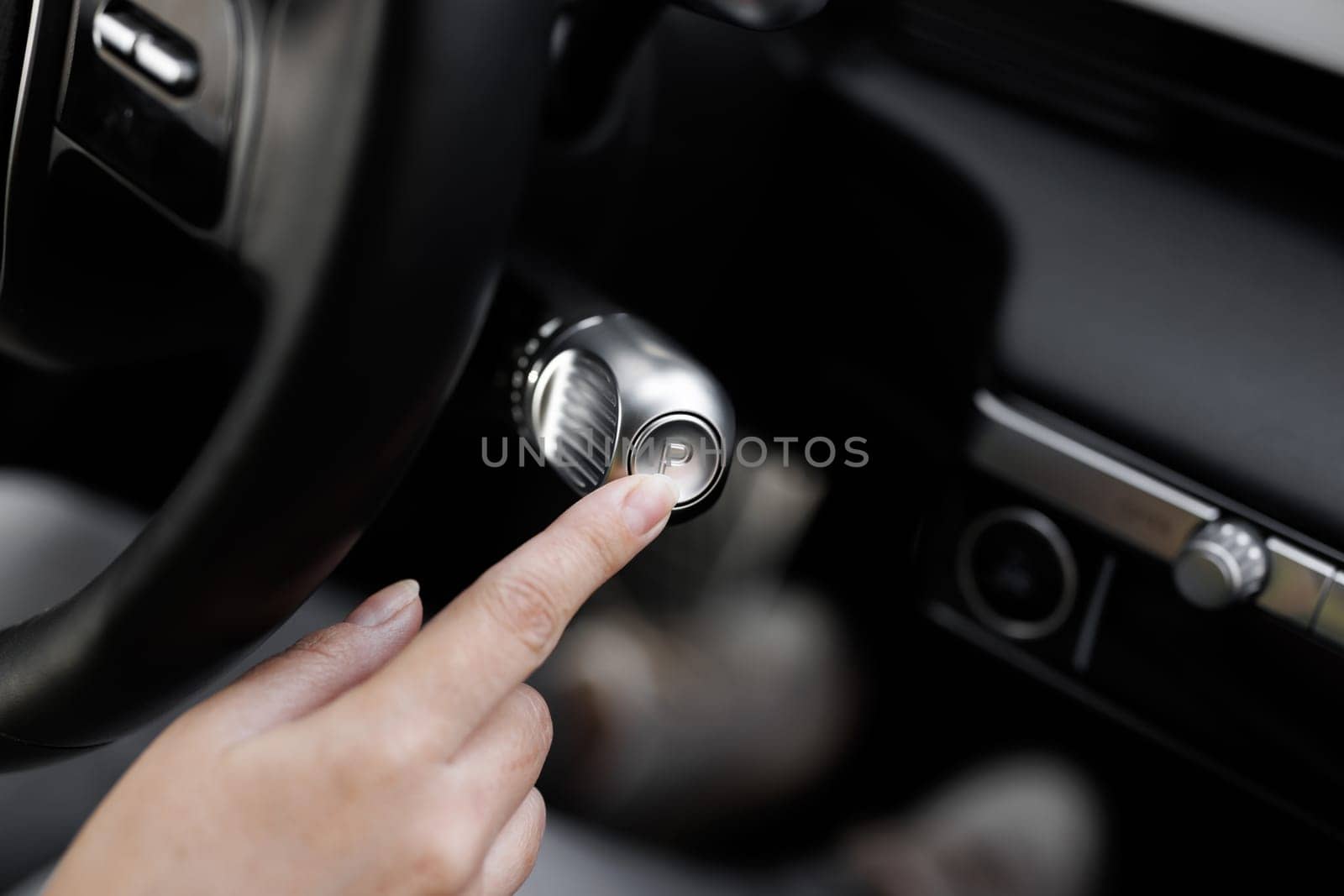 Shifting automatic transmission from P parking mode. Driver In Auto Gear Lever P Mode. The driver's hand moved the gear selector to the Parking mode in the electric car.