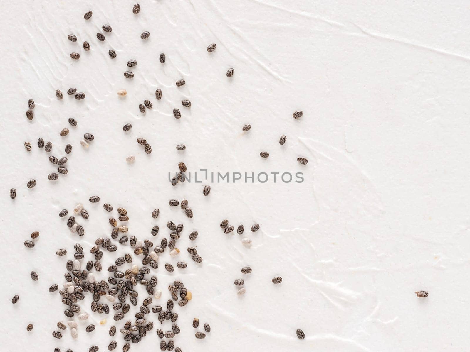 Chia seeds with copy space. Chia seed on white concrete textured background. Top view or flat lay. Copy space. Healthy food and diet concept