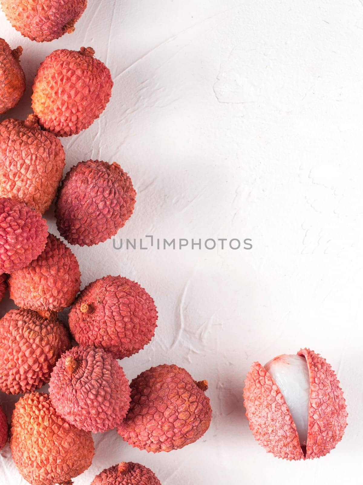 lichee fruit on white textured background. Lichee wit copy space. Top view or flat lay. Vertical