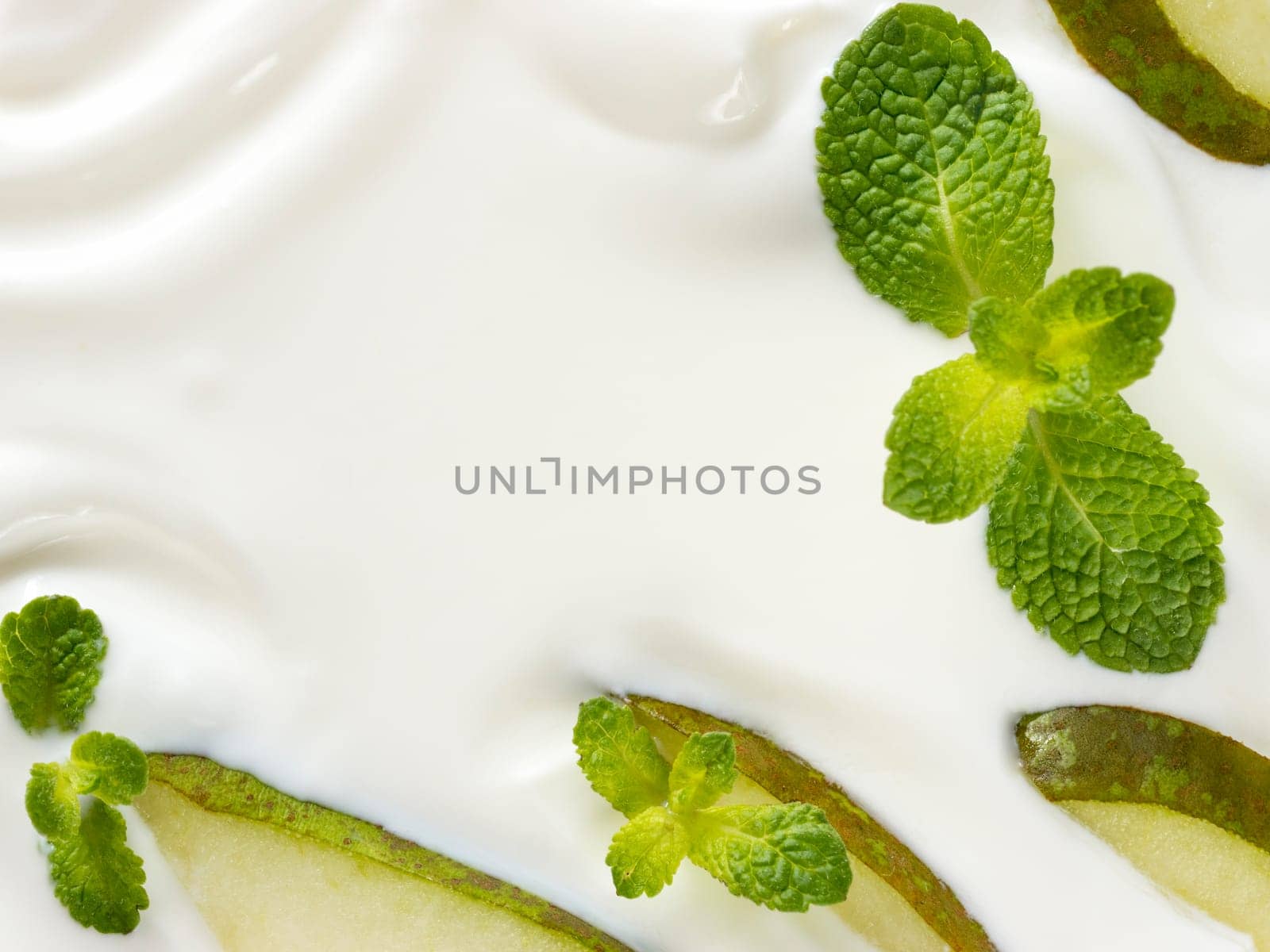 greek yogurt or sour cream texture with pear slice and mint leaf. Close up with copy space. Top view or flat lay