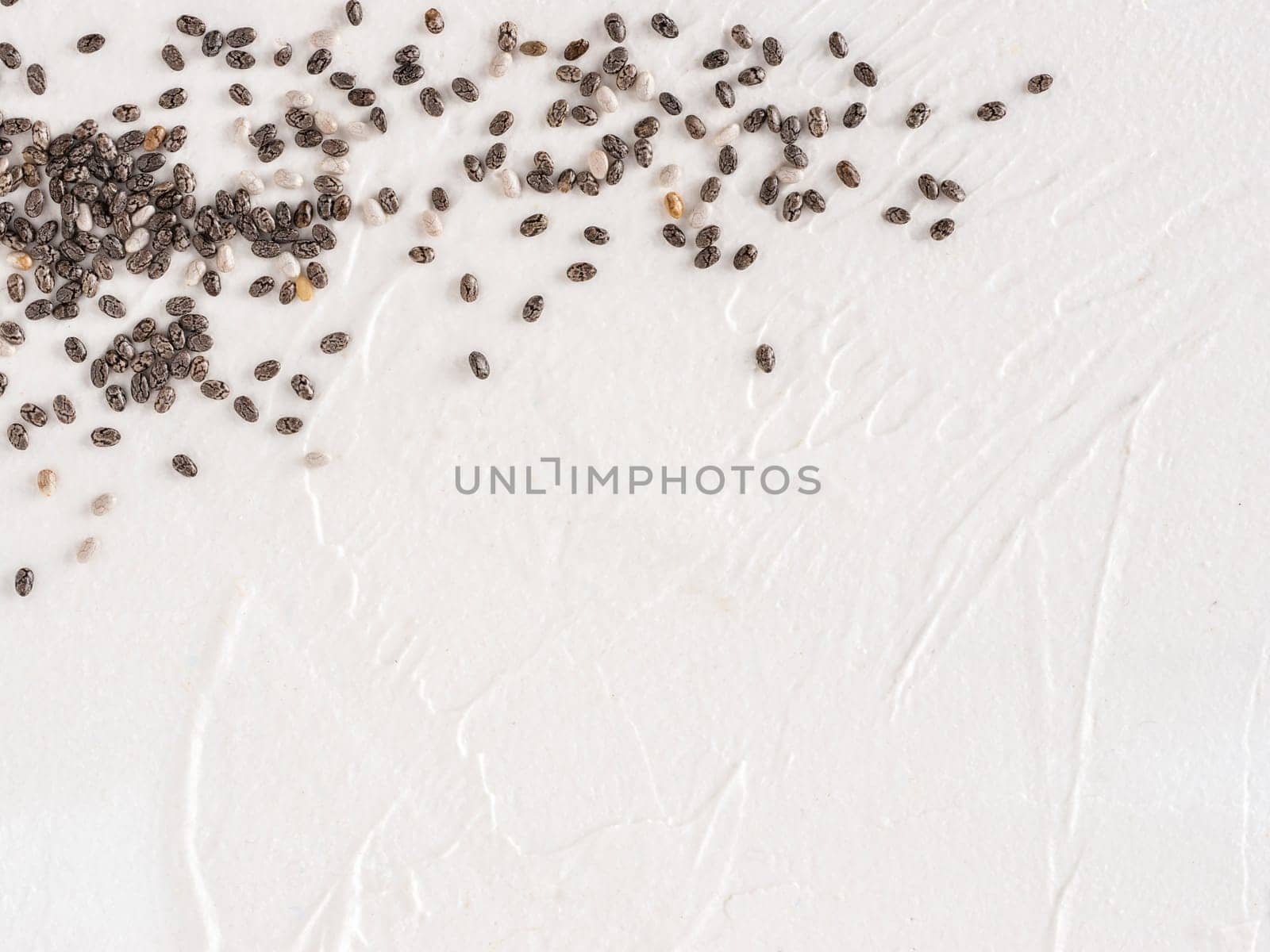 Chia seeds with copy space. Chia seed on white concrete textured background. Top view or flat lay. Copy space. Healthy food and diet concept