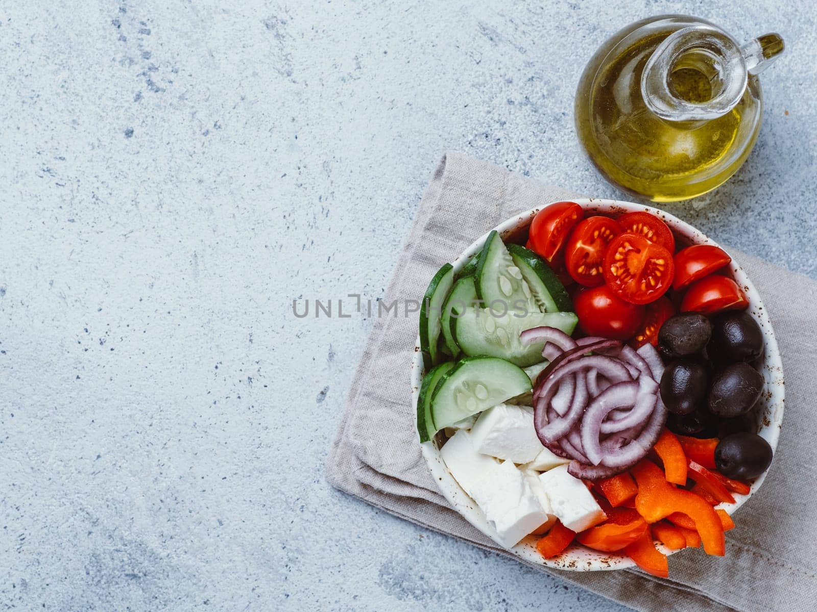 Greek Salad Bowl on gray cement background, copy space. Above view of Bowl Greek Salad. Trendy food. Idea, recept and concept of modern healthy food.