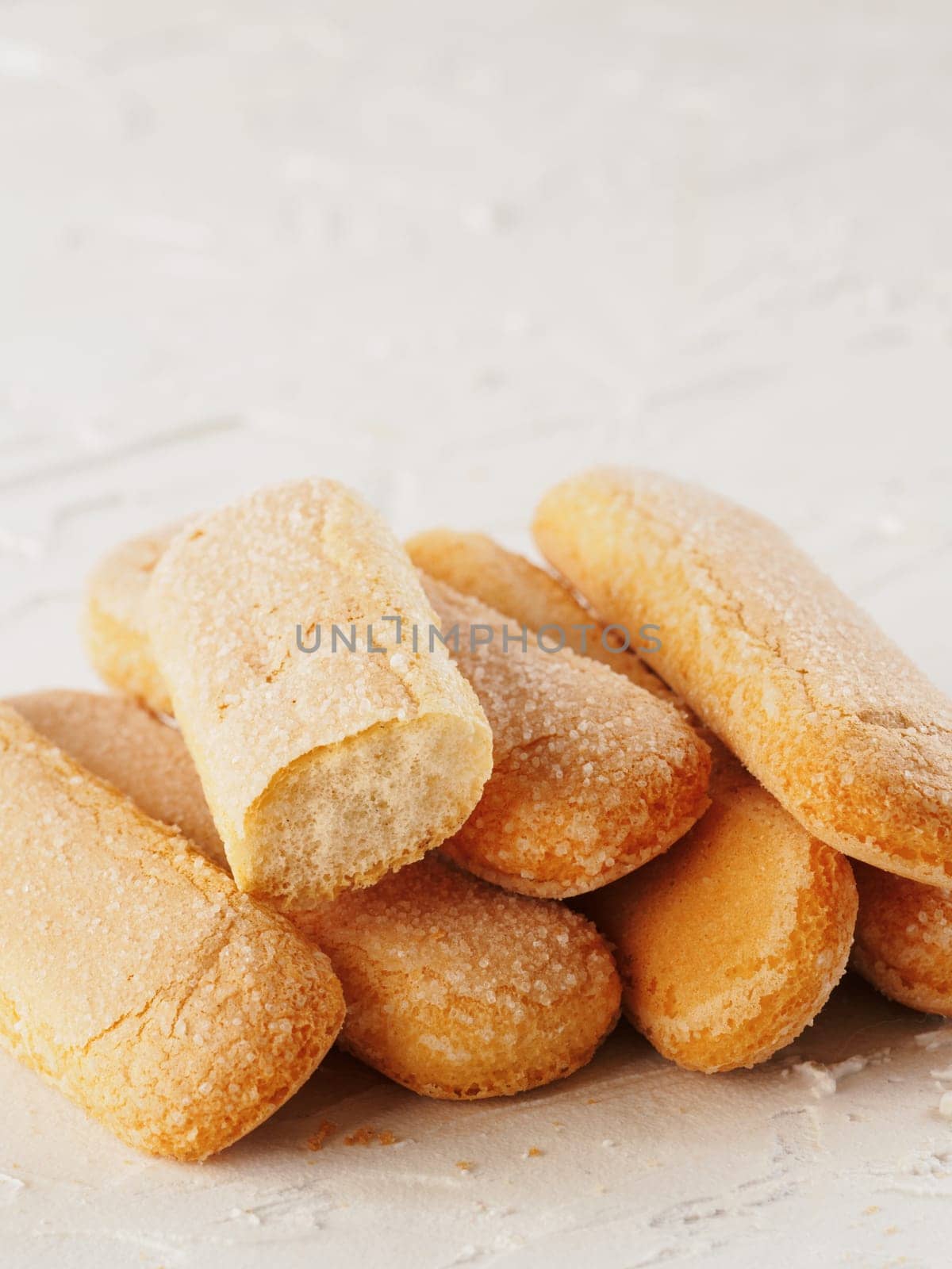 Close up view of ladyfinger biscuit cookie on white concrete background. Italian cookie savoiardi.