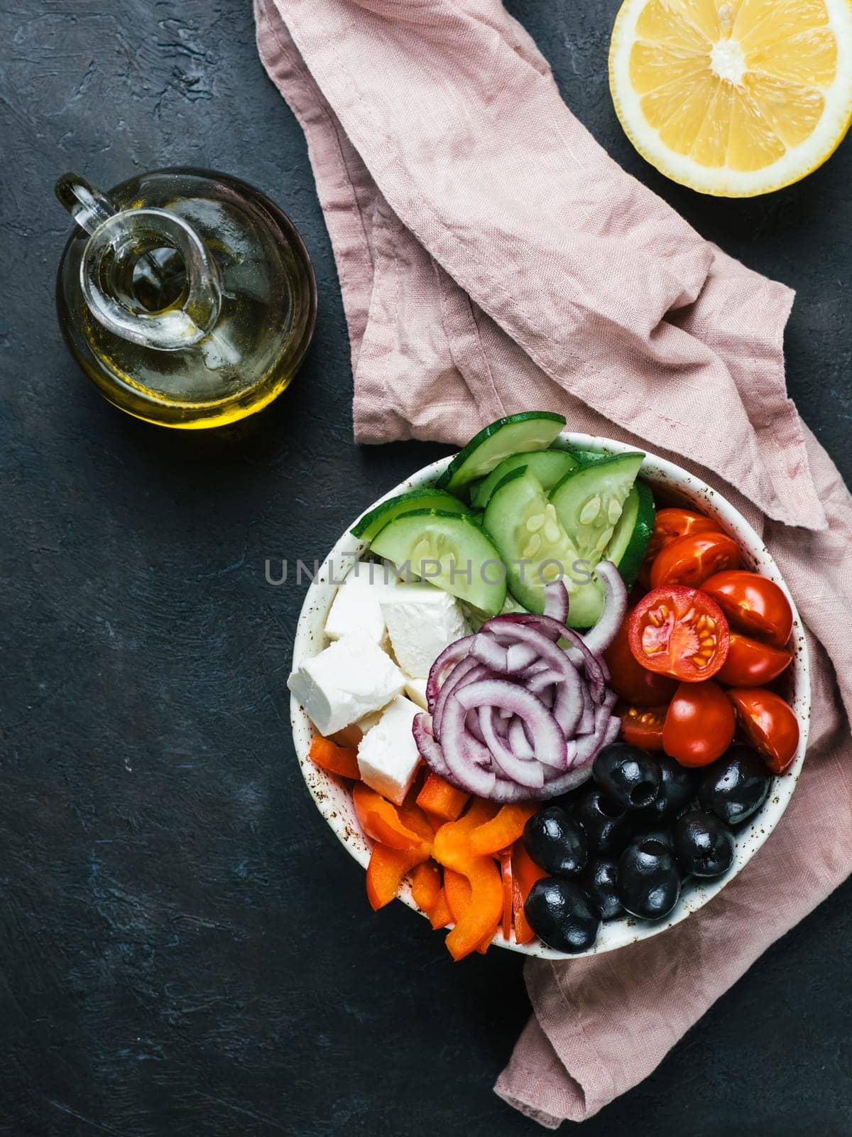 Greek Salad Bowl on dark black background. Above view of Bowl Greek Salad. Trendy food. Idea, recept and concept of modern healthy food. Vertical. Copy space for text.