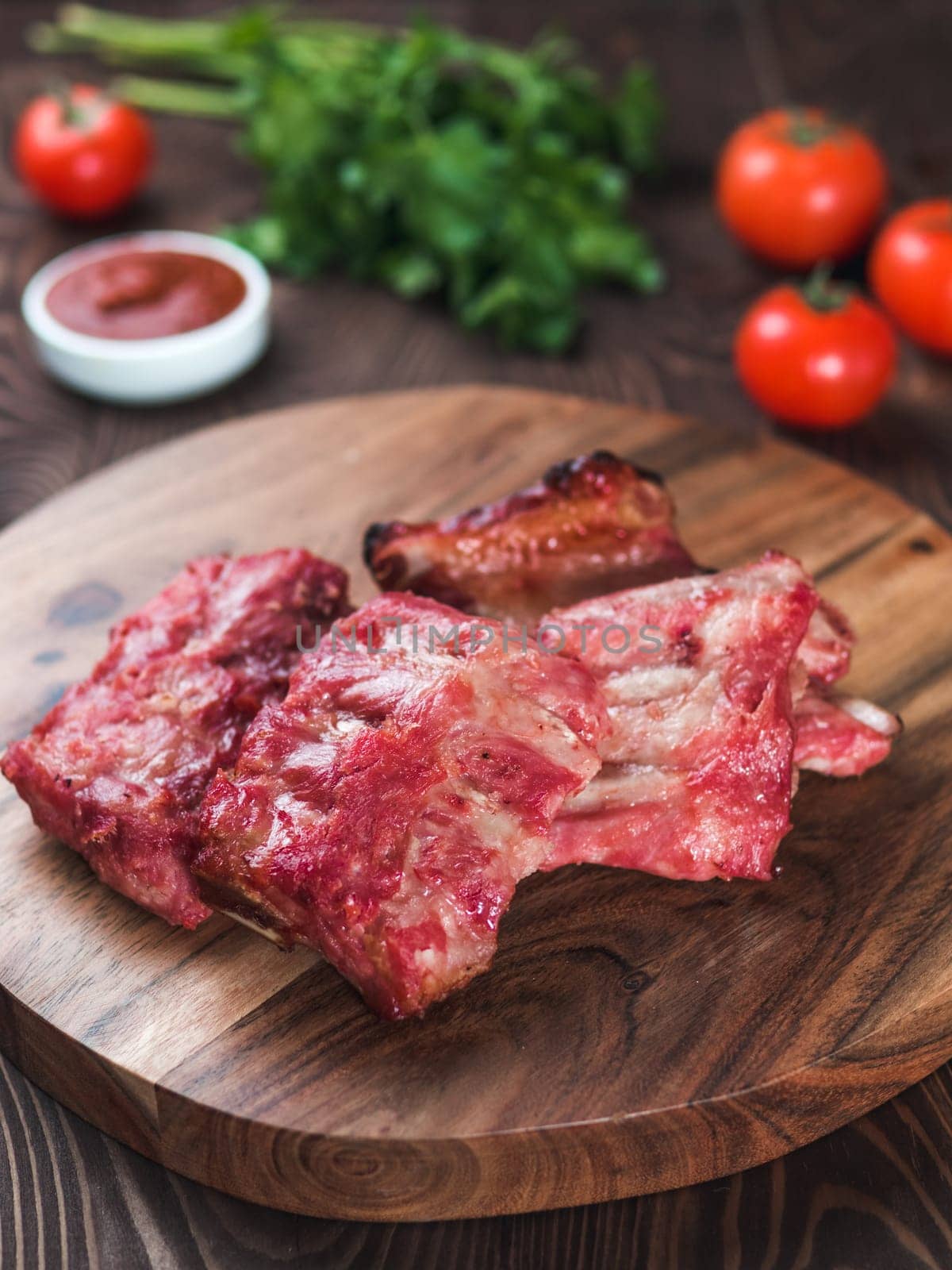 pork ribs on wooden plate. Ready-to-eat pork ribs. Selective focus. Copy space. Vertical
