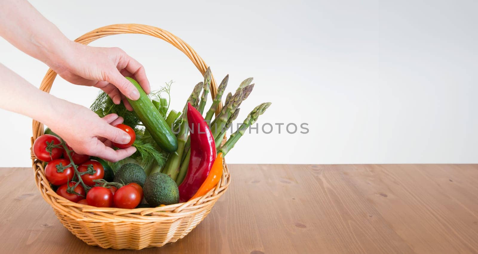 fresh assorted Vegetables in a basket on a wooden table, consumer vegetarian basket, tomatoes, fennel, paprika, asparagus,, cucumbers, avocado, Healthy eating concept, top view, High quality photo