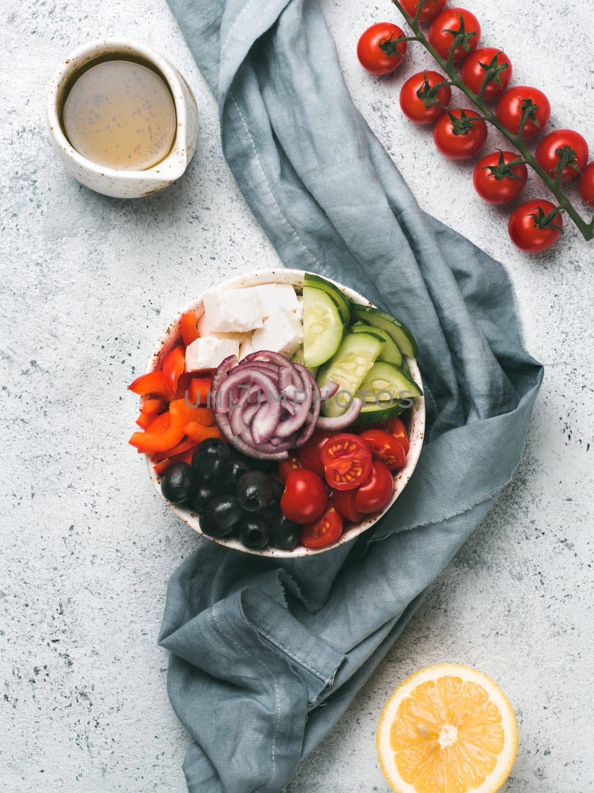 Greek Salad Bowl on gray cement background, copy space. Above view of Bowl Greek Salad. Trendy food. Idea, recept and concept of modern healthy food. Vertical.
