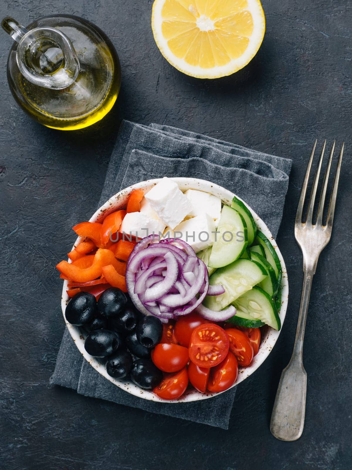 Greek Salad Bowl on dark black background, copy space. Above view of Bowl Greek Salad. Trendy food. Idea, recept and concept of modern healthy food. Vertical.