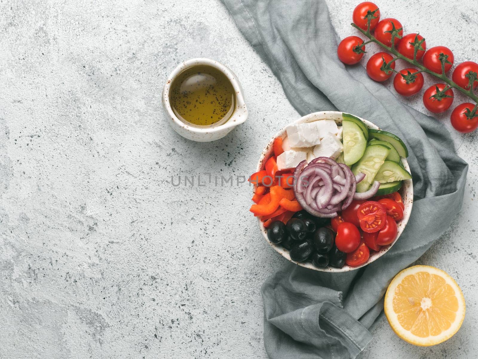 Greek Salad Bowl on gray cement background, copy space. Above view of Bowl Greek Salad. Trendy food. Idea, recept and concept of modern healthy food.