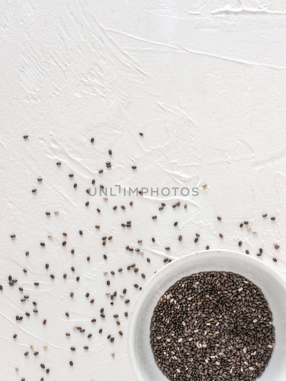 Chia seeds with copy space. Chia seed on white concrete textured background. Top view or flat lay. Copy space. Healthy food and diet concept
