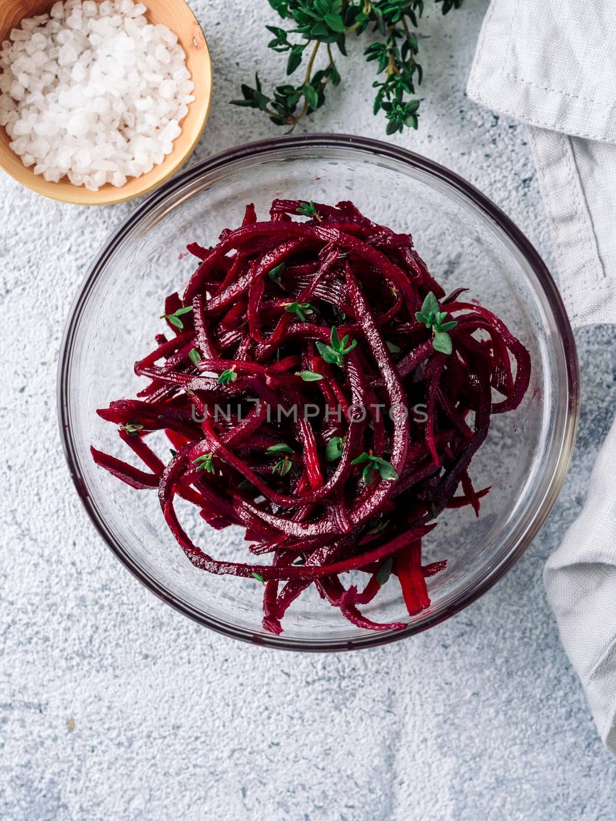 Raw beetroot noodles salad. Vegetable noodles - beet spaghetti on gray background. Copy space for text. Ideas and recipe for Clean eating, raw vegetarian food concept. Top view or flat lay. Vertical.