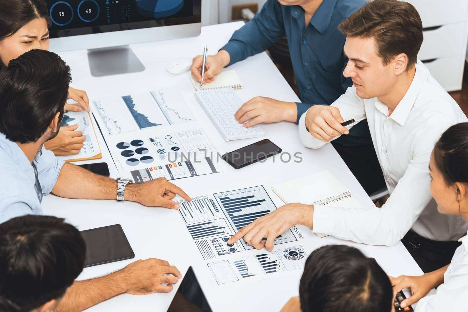 Analyst team utilizing BI Fintech to analyze financial data at table in meeting room. Businesspeople analyzing BI dashboard power on paper for business insight and strategic marketing planning.Prudent