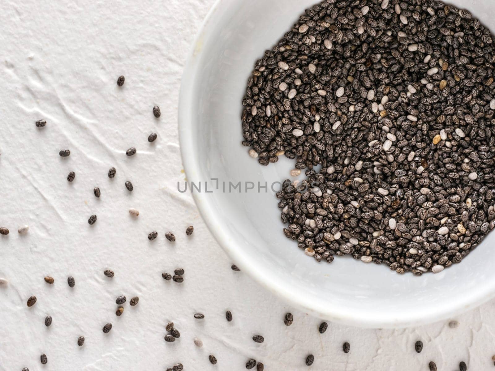 Chia seeds with copy space. Chia seed on white concrete textured background. Top view or flat lay. Copy space. Healthy food and diet concept