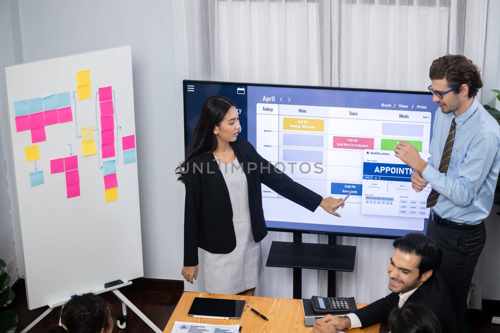 Project manager planning schedules for business task at meeting room, Gantt chart software show on TV screen. Multi ethnic diversity business people and modern business project management. Meticulous