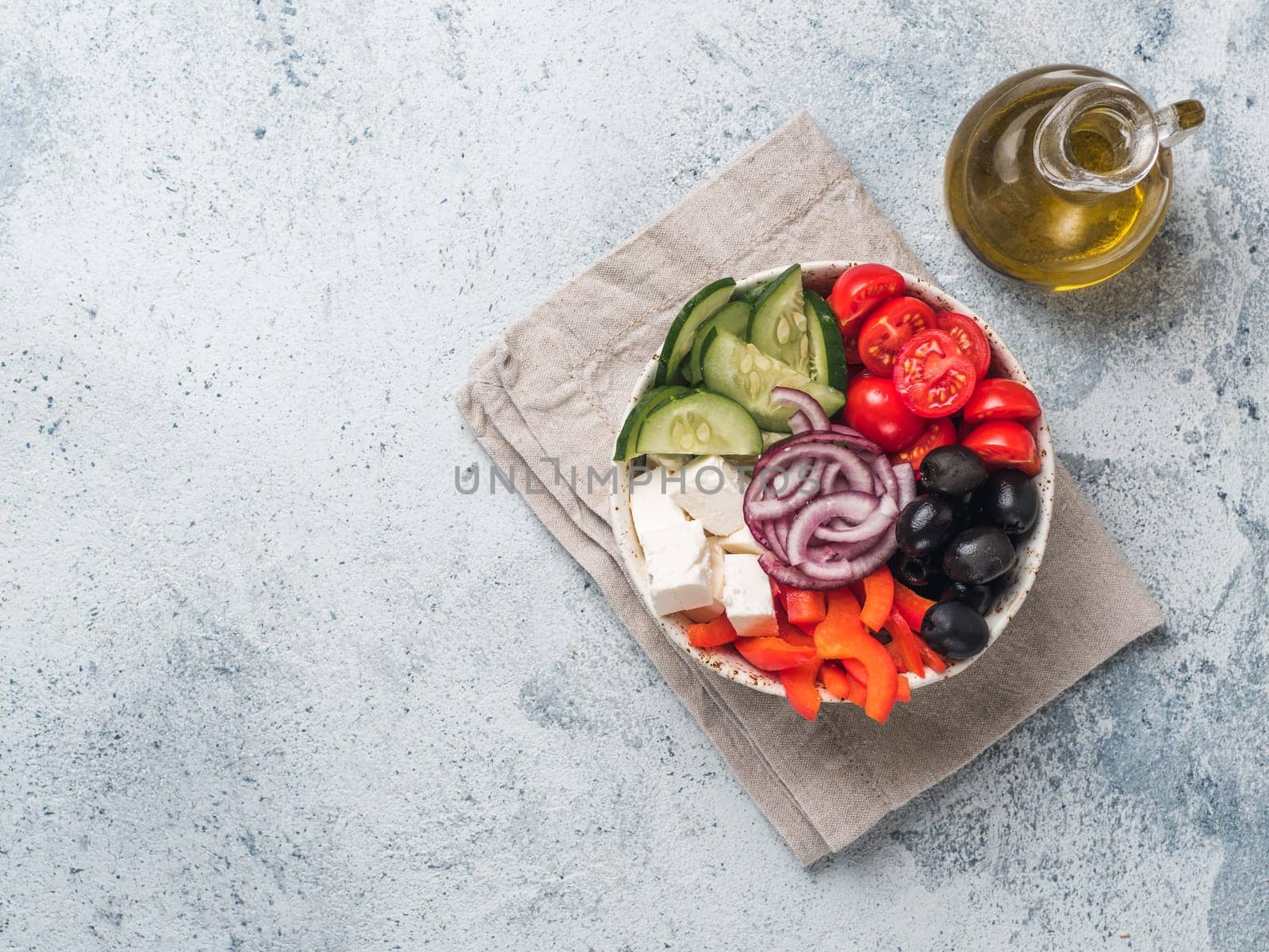 Greek Salad Bowl on gray cement background, copy space. Above view of Bowl Greek Salad. Trendy food. Idea, recept and concept of modern healthy food.