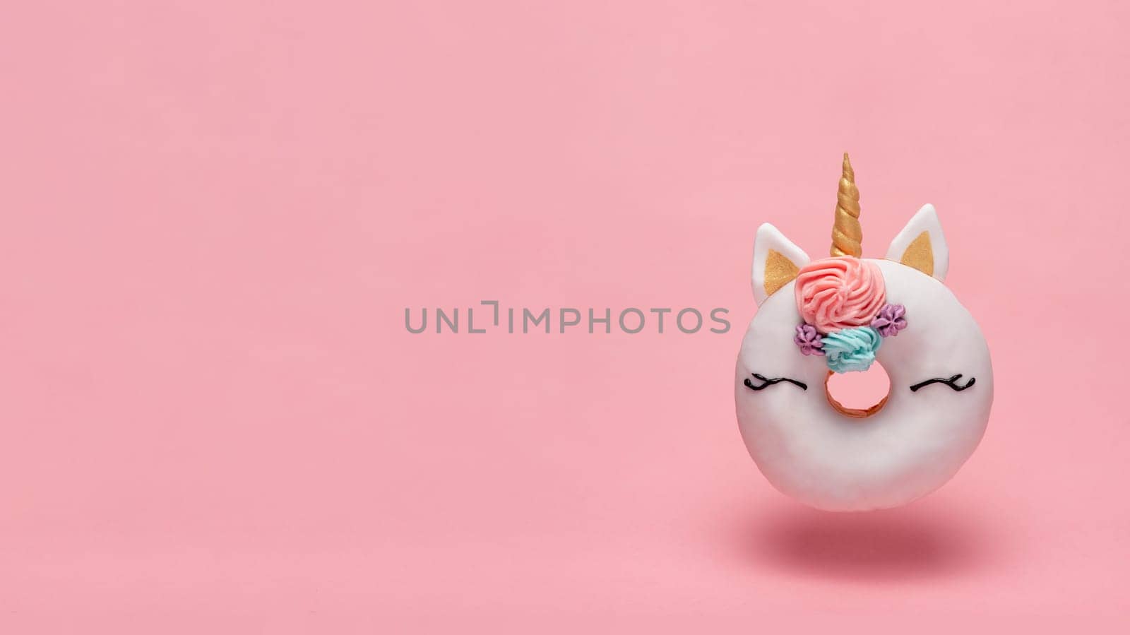 Unicorn donut flying, pink background, copy space by fascinadora