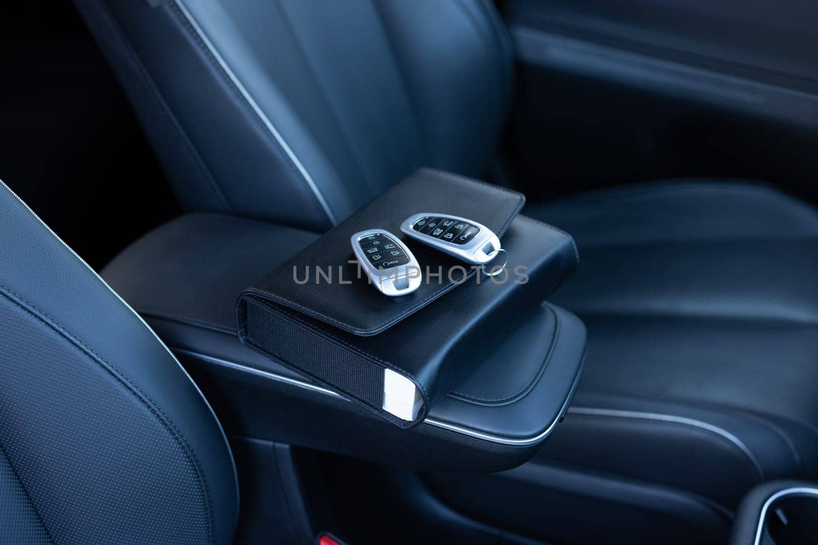 Close-up Of a Car Key Placed On New Car. Car shape keyring and remote control key in vehicle interior. Concept of selling the purchase of leasing or renting a new electric car by uflypro