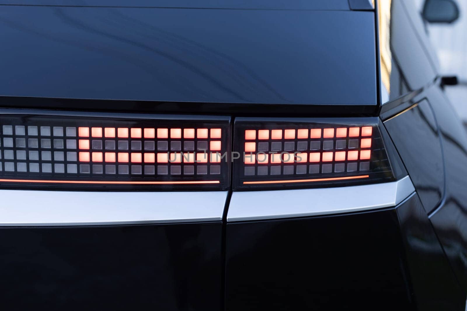 Car taillight. LED red taillight. Closeup tail light of a modern car. Rear light of a car. Rear lamp signals for turning car on street. Signal function to keep them distance. Trunk closeup by uflypro