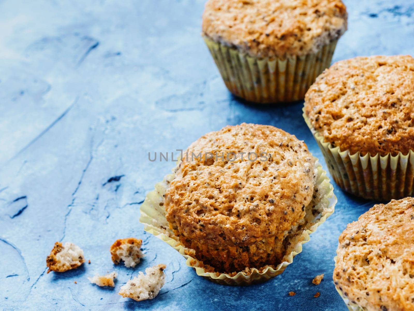 Muffins with chia seeds. Homemade muffin on blue concrete textured background