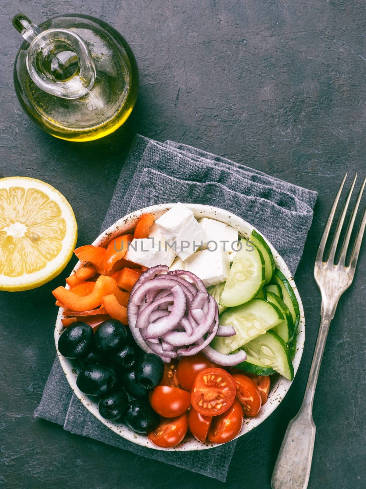 Greek Salad Bowl on dark black background. Above view of Bowl Greek Salad. Trendy food. Idea, recept and concept of modern healthy food. Vertical. Copy space for text.