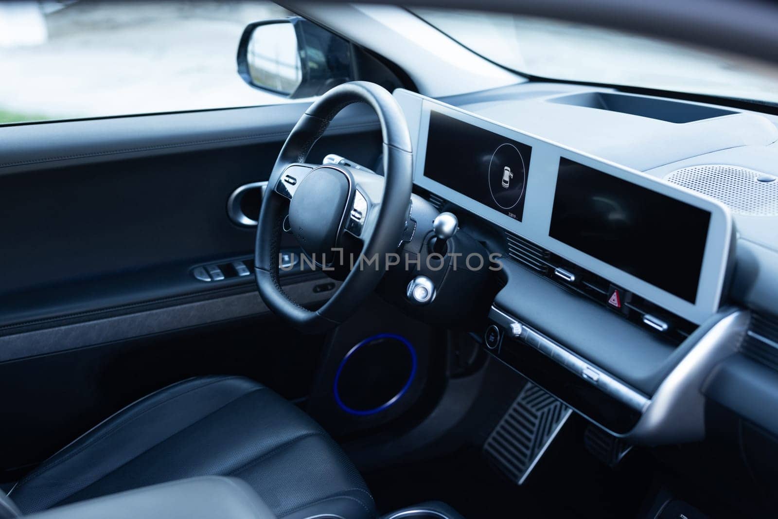 Prestige electric car. Inside car interior with front leather seats, steering wheel, windows, console, gear shift, electric buttons, digital speedometer. Luxury car interior. Car detailing series by uflypro