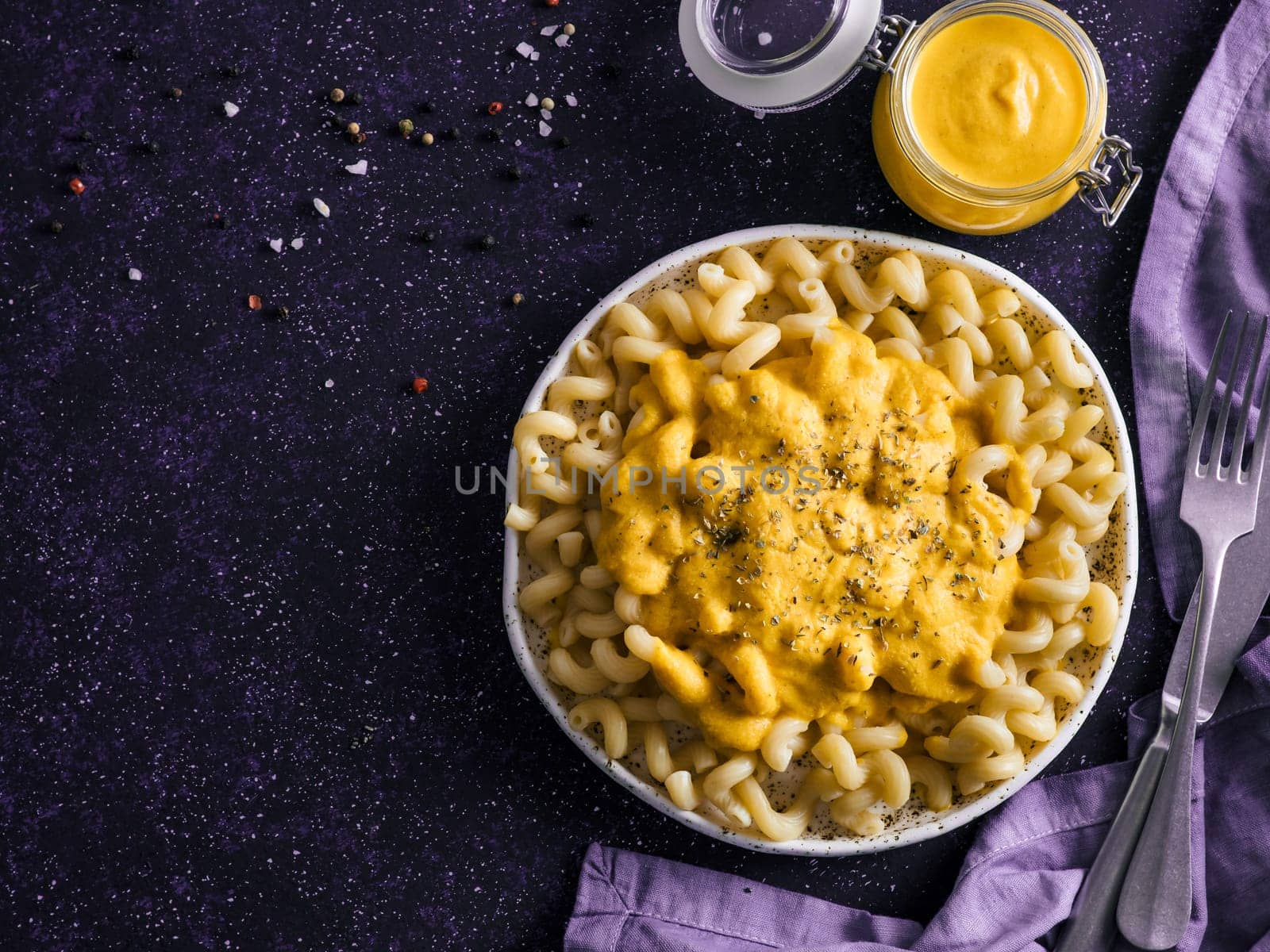 Pasta with vegan creamy chia cheddar sauce on gray background. Ideas and recipe for healthy diet or vegan food. Dish with homemade plant based Chia Cheeze Sauce. Copy space