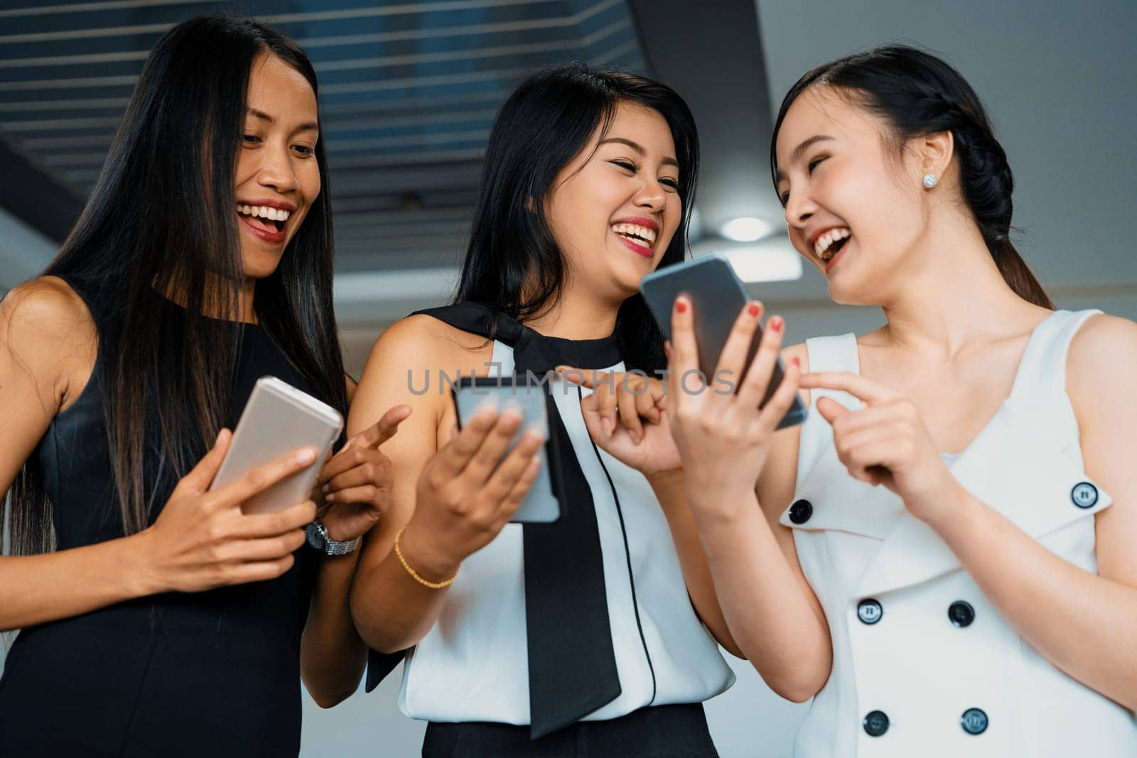 Three women friends having conversation while looking at mobile phone in their hands. Concept of social media, gossip news and online shopping. uds