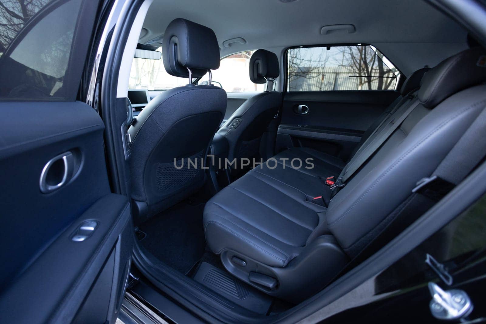 Rear leather passenger seats in modern lux electric car. Leather car passenger seat. Control unit with electric seat adjustment media system for rear passengers in luxury car. Car interior detail by uflypro