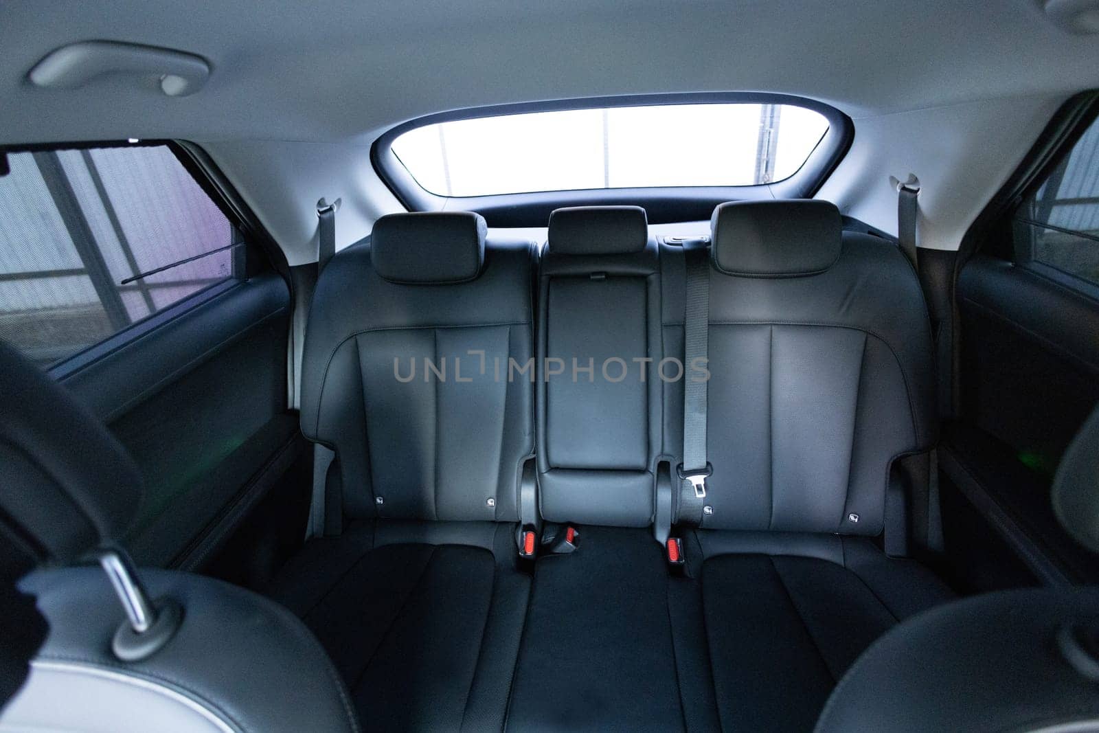 Luxury car rear leather seats row. Interior of new modern clean expensive car. Passenger seats with leather. Closeup details. New electric car inside. Car cleaning theme by uflypro