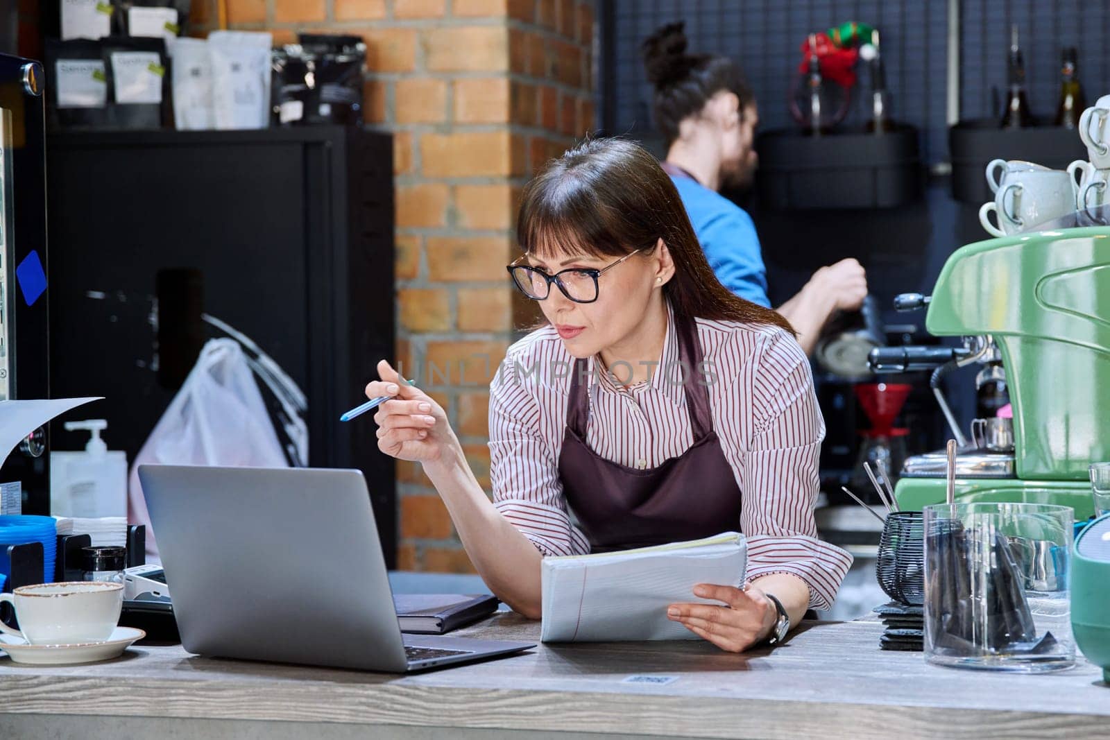 Colleagues, partners, man and woman behind counter in coffee shop by VH-studio